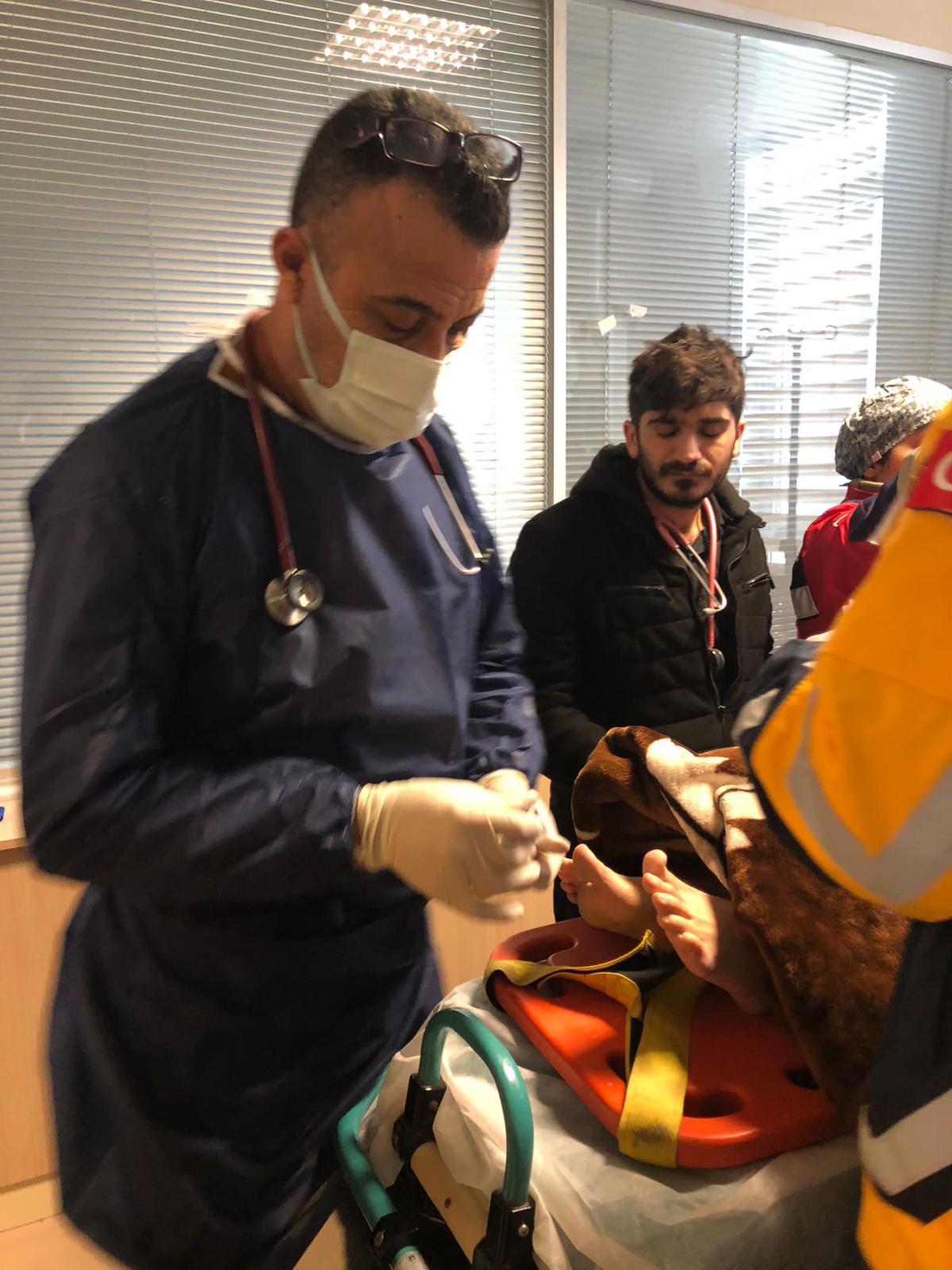 طبيب العظام الفلسطيني أنور الكرد يساعد أحد الجرحى الناجين من الزلزال. (صورة خاصة بوفا)